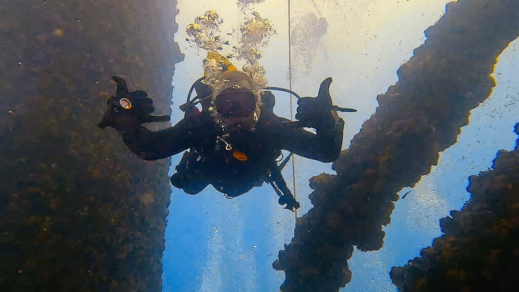 Michael Bricker scuba diving near underwater wreckage